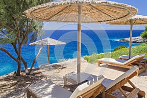 Straw beach umbrellas and sunbeds on the west coast of Zakynthos island, Greece