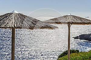 Straw beach umbrellas and sunbeds on the west coast of Zakynthos island, Greece