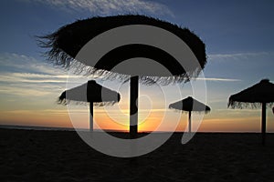 Straw beach umbrellas at Sunset