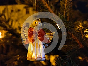 Straw Christmas decoration of an angel hanging on the spruce tree branch