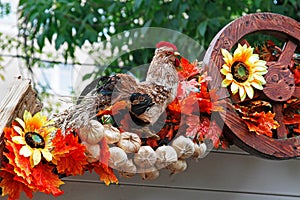 Straw cock, sunflowers, onions and wheel as autumn decoration for street festival `Moscow autumn`