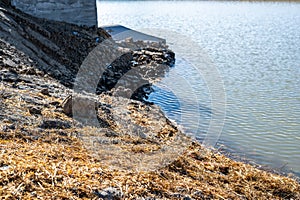 straw covered slope leading to a stormwater retention basin used to control soil erosion at a construction site