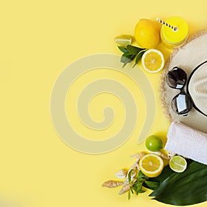 Straw foman`s hat, sun glasses and beach accessory with detox citrics water on yellow. Top view. Flat lay. Copy space