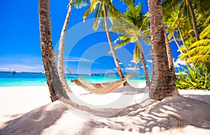 Straw hammock on tropical white sandy beach