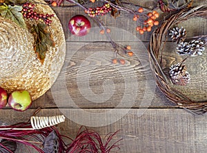 Straw hat and autumn decor on rustic wooden plank background