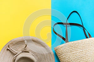 Straw hat with bow wicker handwoven beach bag on bright yellow mint blue duotone background. Travel vacation fashion