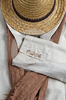 Straw hat, brown scarf and classic linen coat. Summer trends