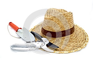 Straw hat and hand trowel and pruning shear on white photo