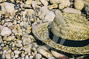 Straw hat lying on top of beach stones photo
