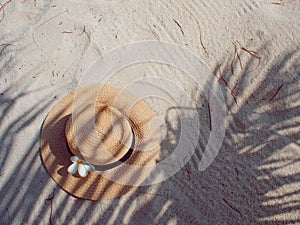 Straw hat on sand, sun protection concept.