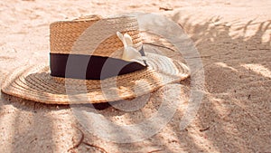 Straw hat on sand, sun protection concept.