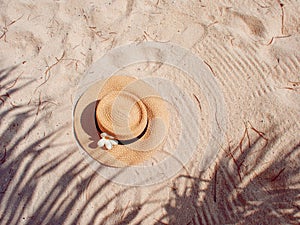 Straw hat on sand, sun protection concept.