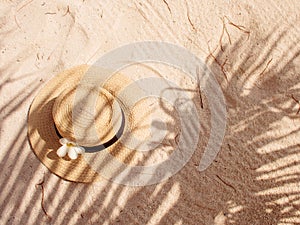 Straw hat on sand, sun protection concept