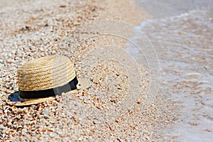 Straw hat on sand, sun protection concept. Women`s beach accessories or summer outfit