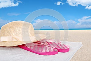Straw hat sandals on a beach towel