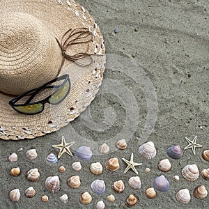 Straw hat and sunglasses on beach sand