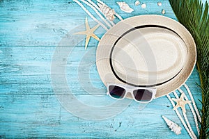 Straw hat, sunglasses, palm leaves, rope, seashell and starfish on table top view, flat lay. Summer holidays, travel, vacation.