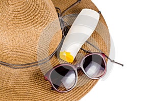 Straw hat with sunglasses and sun lotion