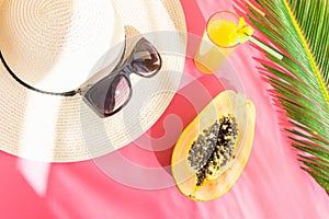 Straw Hat Sunglasses Tall Glass with Fresh Citrus Tropical Fruit Juice Papaya Palm Leaf on Pink Background. Sunlight Leaks