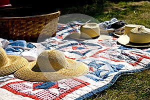 Straw Hats and Picnic Basket on Quilt