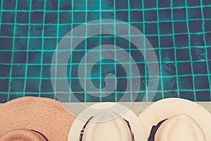 Straw hats at the pool edge with palm reflections in the water