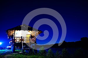 Straw house near small lake with sky in nightime photo