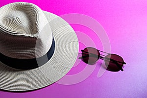 Straw Panama Hat and Sunglasses on a Pink Surface