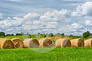 Straw roll on a green field with a beautiful sky