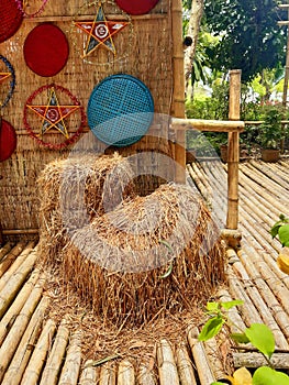 Straw rolls on a bamboo floor and raffia wall with oriental decoration. Vietnamese culture