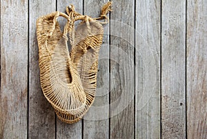 Straw shoes on wooden wall