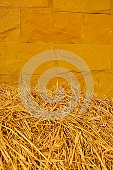 Straw stack and yellow brick wall