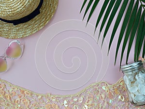 Straw summer hat, golden decorative net, heart-shape sunglasses, shells and palm leaf