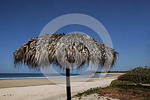 Straw Umbrella on a wide open beach.