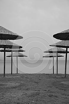 Straw umbrellas in an empty beach