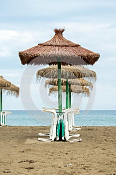Straw umbrellas with sunbeds on the beach photo