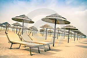 Straw umbrellas and sunbeds at Rimini beach in Italy