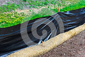 Straw wattles and plastic fence placed along dry waterway photo