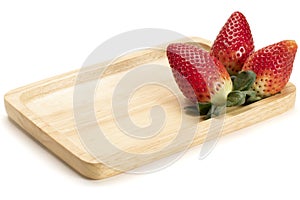 Strawberries on a bamboo plate, isolated on white background