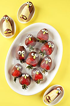 Strawberries and bananas in chocolate in the form of birds. Cute idea for kids party.