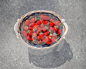 Strawberries basket on gray concrete background