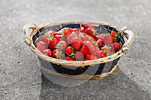 Strawberries basket on gray concrete background