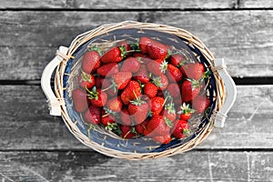 Strawberries basket on old wood background