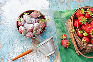 strawberries in a basket sprinkled with powdered sugar on an old wooden table