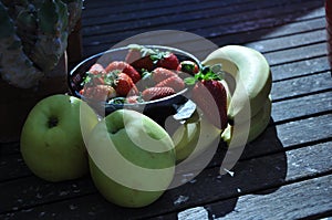 Strawberries in the basket. Strawberries on the table. with apple and bananos photo