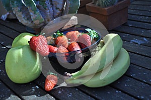 Strawberries in the basket. Strawberries on the table. with apple and bananos photo