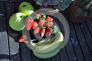 Strawberries in the basket. Strawberries on the table. with apple and bananos photo