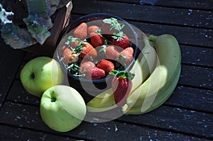 Strawberries in the basket. Strawberries on the table. with apple and bananos photo