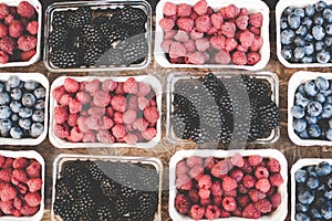 Strawberries blueberries and raspberries in carton boxes