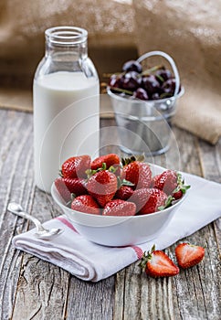 Strawberries in a Bowl with a Bottle of Milk