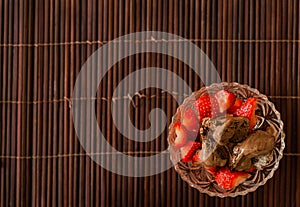 Strawberries and chocolate ice cream in a crystal bowl on a bamboo mat